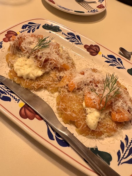 Crispy golden potato pancakes topped with smoked salmon, cream, grated cheese, and dill