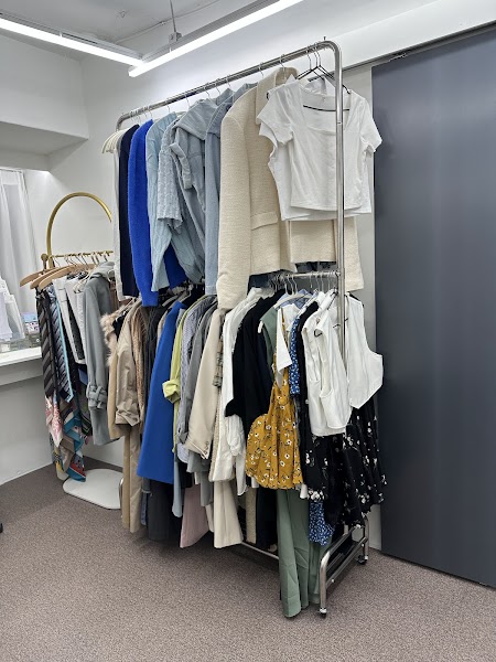 A clothing rack filled with various garments in a professional personal color analysis studio