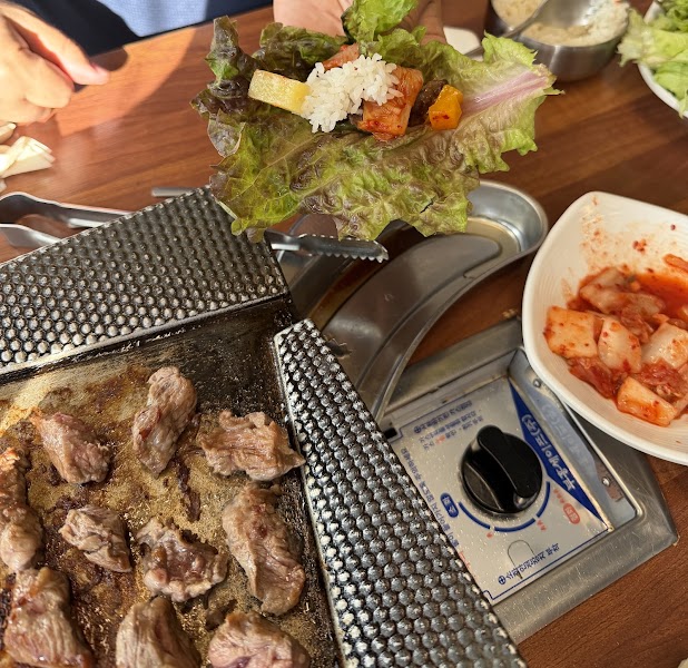Fresh ssam lettuce wrap assembled with grilled meat, steamed rice, and kimchi