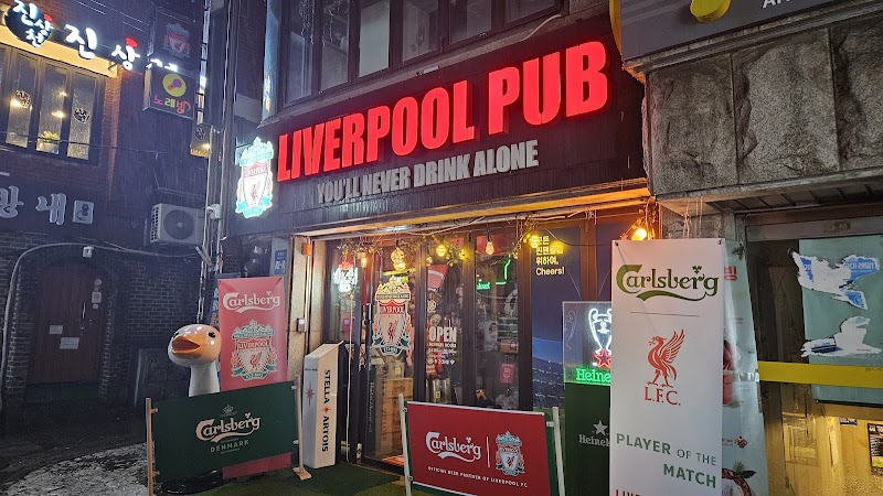 Exterior storefront banner of Liverpool Pub at night showing Carlsberg signage
