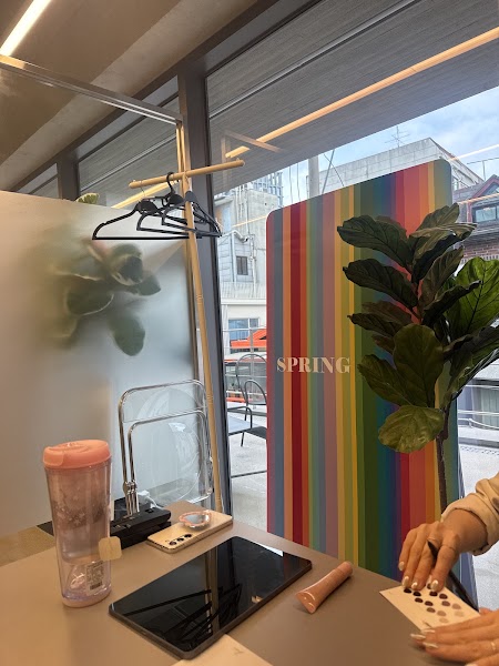 Interior of a personal color consulting office with a rainbow-striped panel labeled SPRING and a desk for color analysis.