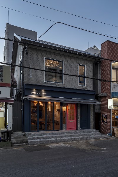 Exterior view of the Bistro oven and vine restaurant in Seoul at twilight.