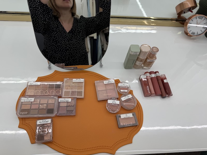 A selection of various makeup palettes and lip products arranged on a desk at a personal color analysis consultation space