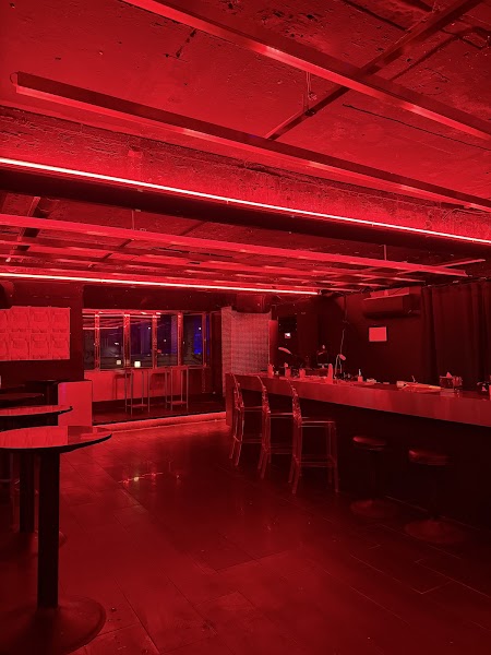 Interior of MICHIN SEOUL bar featuring industrial architecture and intense red atmospheric lighting