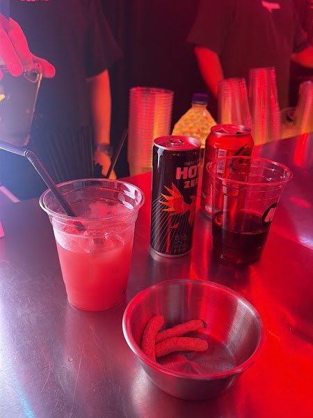 Plastic cups with cocktails and an energy drink can on a stainless steel bar counter at Michin Seoul