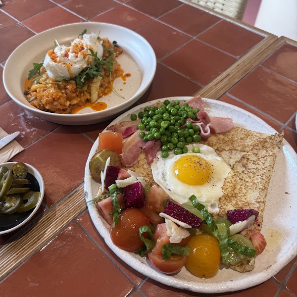 Brunch plates featuring savory crepe with fried egg and risotto bowl