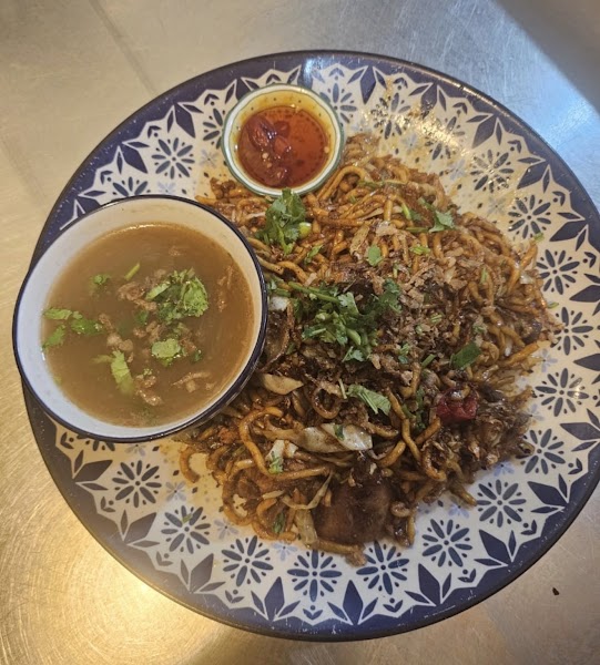 Stir-fried noodles with dipping broth and chili condiment.