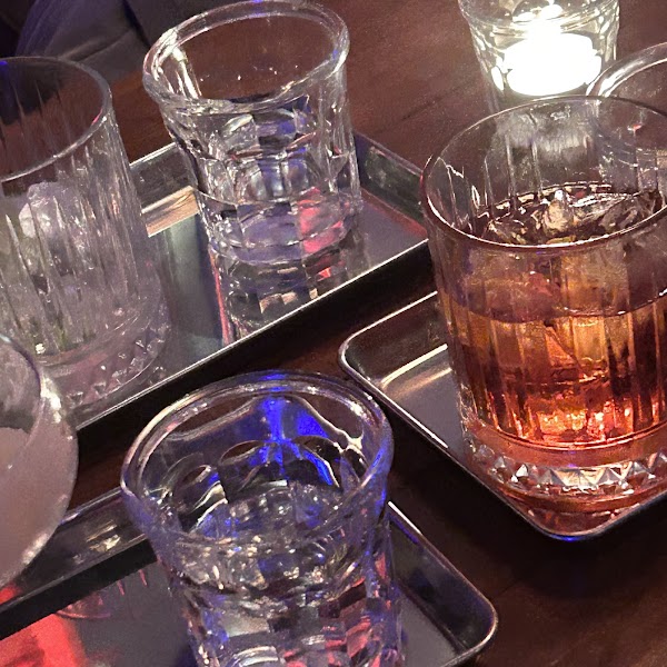 Detailed crystal glassware and bar setting on a dark wooden table