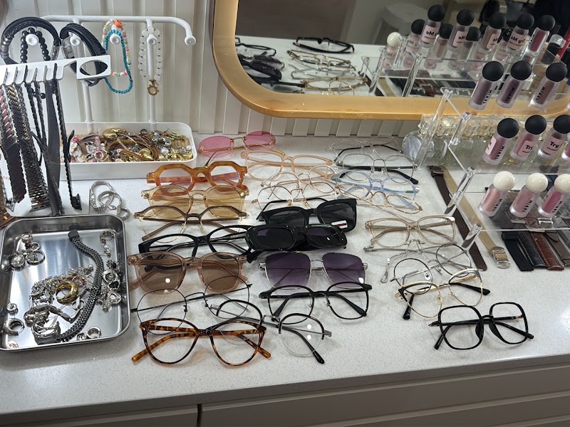 A collection of various eyeglasses and jewelry displayed on a white dressing table