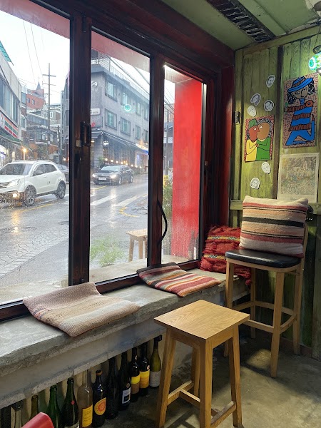 View from inside Gitana Natural Wine Bar looking out through the window onto Sinheung-ro