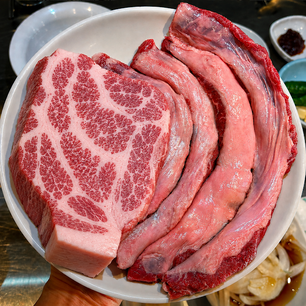 Fresh plate of marbled raw pork and beef cuts