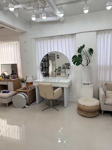 White vanity station with round mirror and natural studio daylight at Meime Color & Beauty