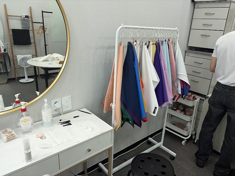 Personal color analysis studio with a rack of multicolored fabric drapes and a vanity mirror