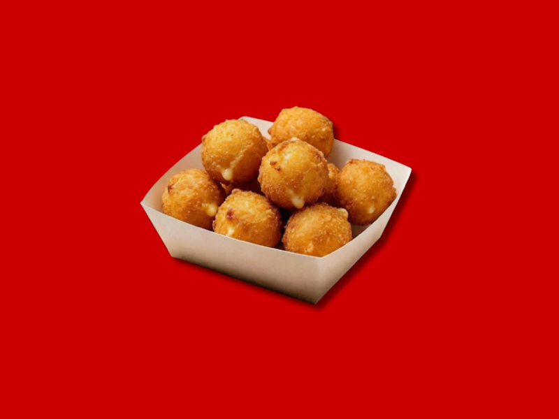A paper tray filled with golden-brown fried cheese balls set against a vibrant red background.