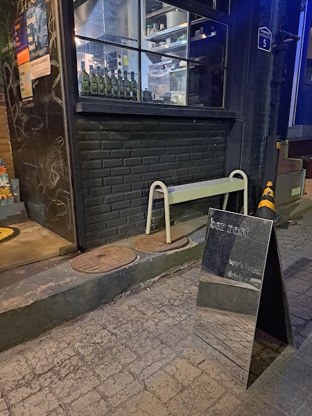 Street-level night storefront of Leseuteu with warm glowing windows and sidewalk sign