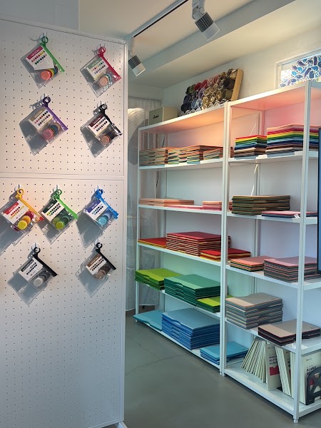 Pegboard displaying color swatches and shelves filled with colorful fabric samples at Image HO