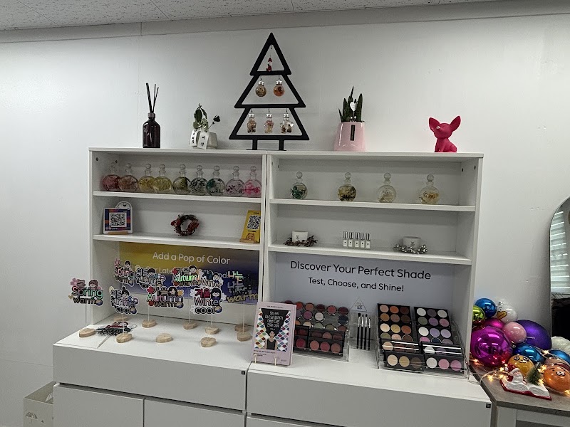 White shelves displaying makeup palettes and color analysis props in a bright studio environment.