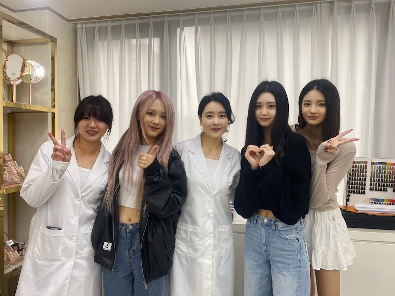 Personal color consultant in a lab coat posing with clients in the studio space