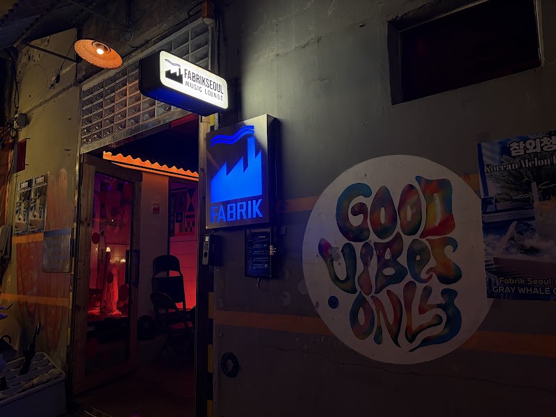 Night exterior entrance to Fabrik Seoul music lounge with illuminated logo signage