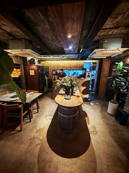Interior of Namsan Winery featuring a central wooden barrel table and rustic ambient lighting