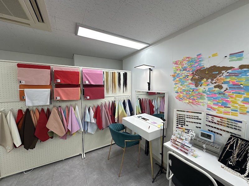 An indoor color consulting studio with fabric drapes, a vanity, and a world map covered in sticky notes.