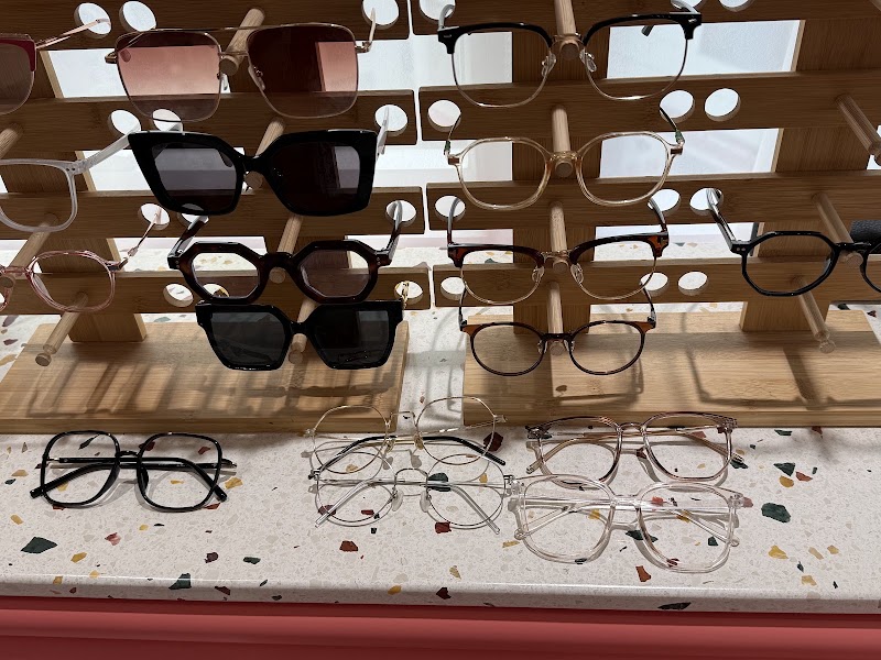 Selection of eyeglasses and frame styles displayed on wooden stands for facial harmony matching