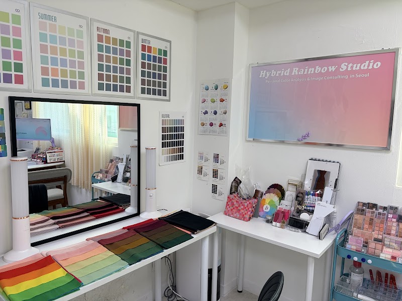 Interior view of Hybrid Rainbow Studio featuring color analysis drapes, charts, and beauty supplies in a professional consultation room.