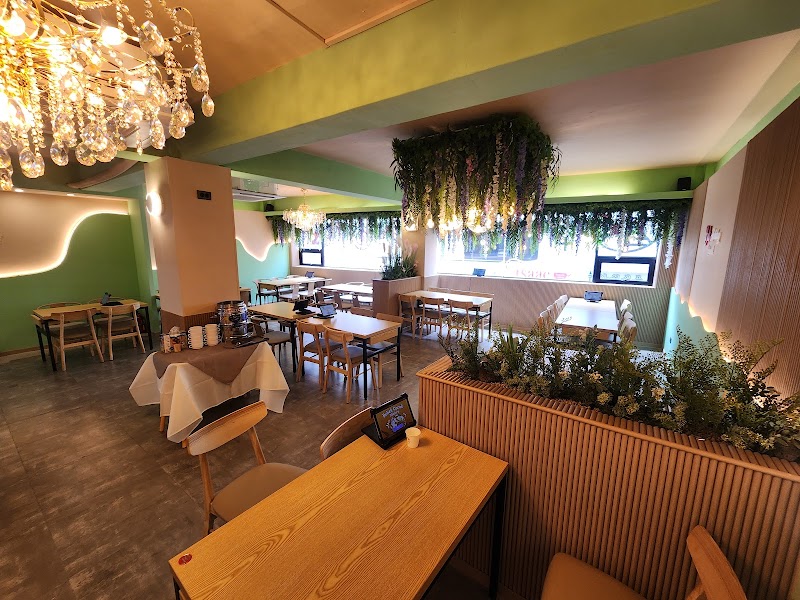 Interior of Bali Holiday Halal Restaurant in Seoul featuring green walls, wooden tables, and chandelier