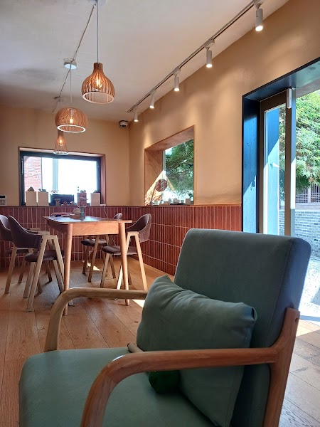 Interior of Dadam Tea House in Seoul with wooden furniture and sage green armchairs.