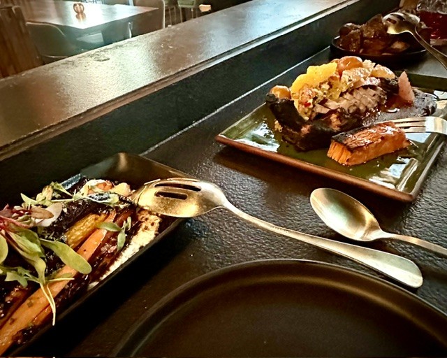 Beautifully prepared wood-roasted vegetable sides and sliced meat plates