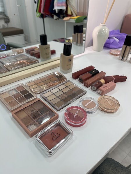 Cosmetic palettes, lipsticks, and foundation bottles arranged on white consultation vanity