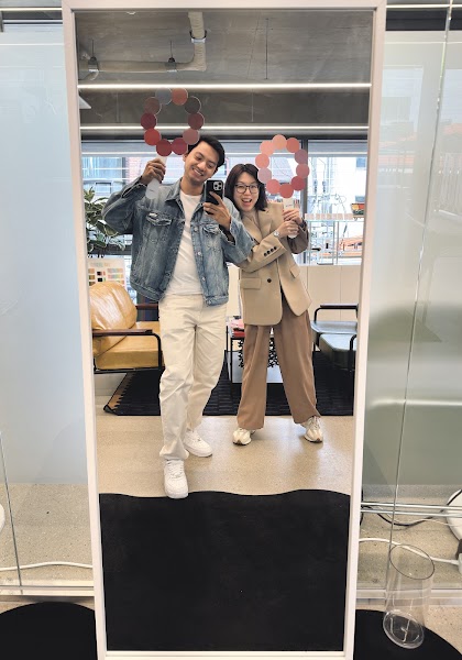 Two people reflected in a mirror holding color palette fans at COCORY Color Gangnam studio.