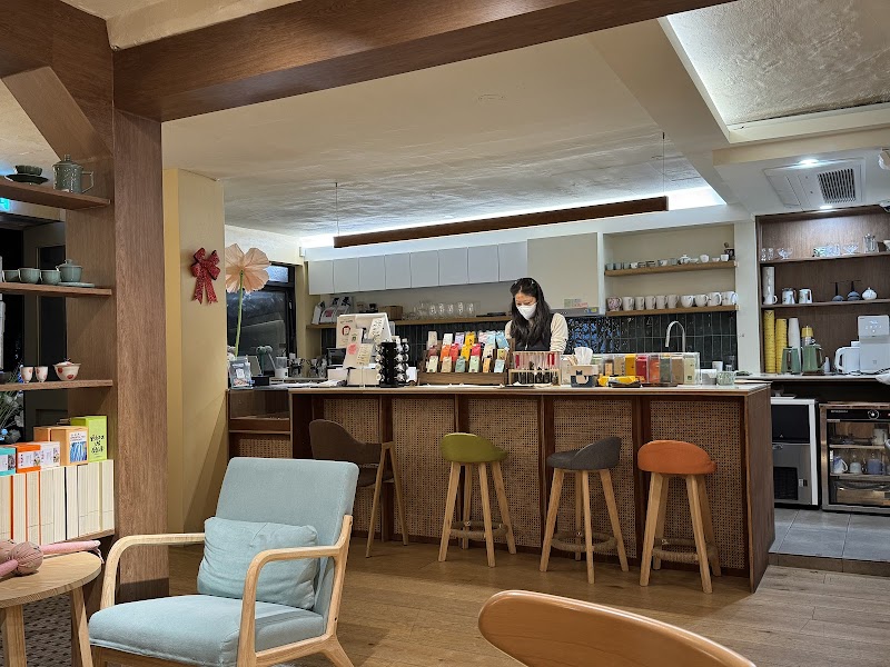 Interior view of Dadam tea house in Seoul with a wooden service counter, bar stools, and comfortable seating.