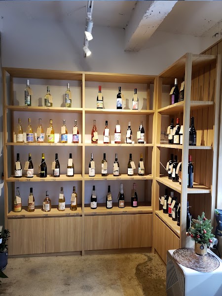Wooden wine shelves filled with various bottled wines at Curated by Label in Seoul