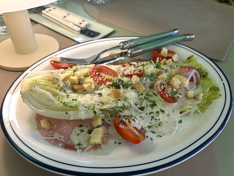 Wedge salad with crisp romaine, cherry tomatoes, golden croutons, and creamy dressing on a navy trimmed plate