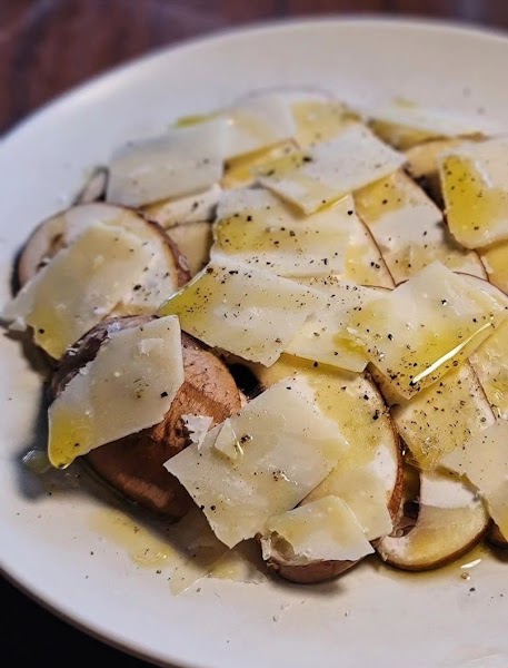 Mushroom carpaccio with shavings of Parmigiano-Reggiano cheese, olive oil, and cracked pepper
