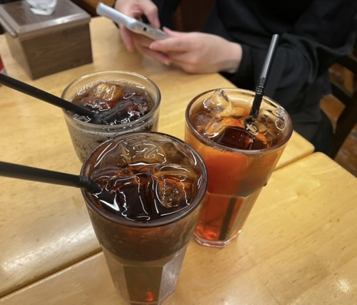 Three tall glasses of iced Malaysian beverages on a dining table.
