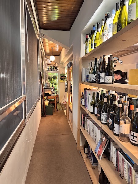 Narrow wooden corridor lined with curated books and wine bottles