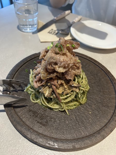 Gosari fern pasta coated in herb sauce and topped with sliced seared beef