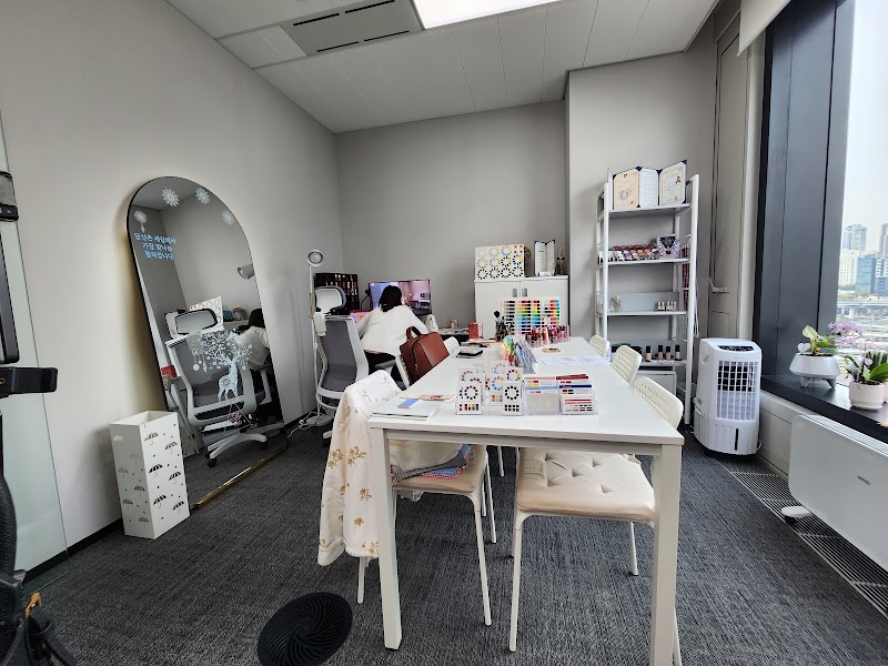 An office interior for color consultation with a desk, chairs, a tall mirror, and shelves displaying color palettes and beauty products.