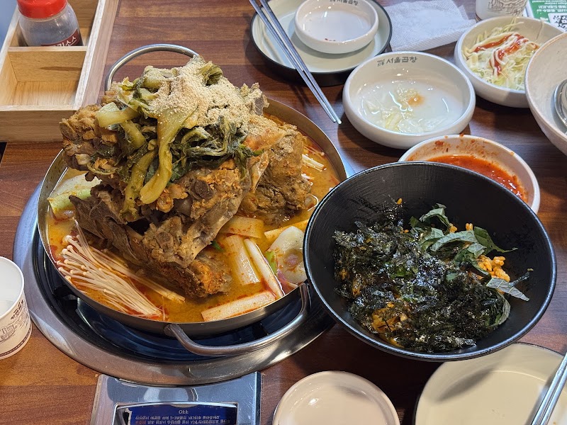Gamjatang hotpot pot and side rice bowl on dining table