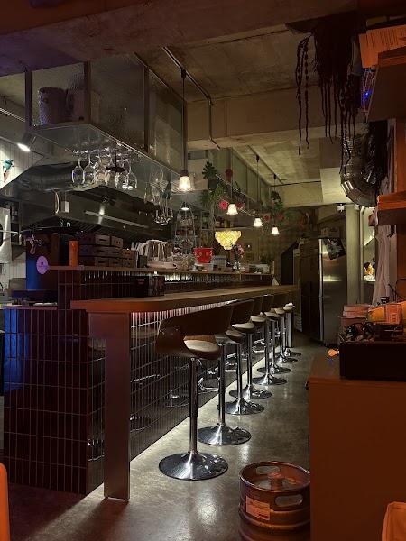 Dimly lit wooden bar counter with stools and stemware