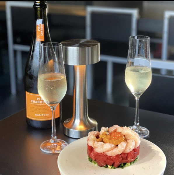 Chilled sparkling wine and seafood pairing on a dark table at PAUSE NAMYEONG