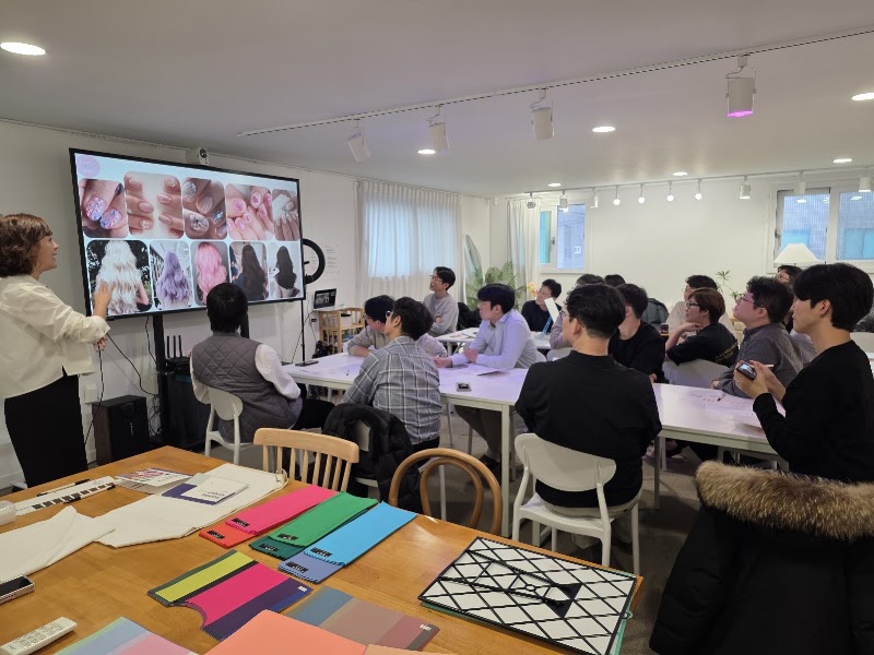 Presenter leading personal color analysis workshop with digital screen and color swatches on tables