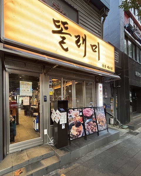 Exterior entrance of Dolraemi Korean BBQ restaurant with illuminated sign