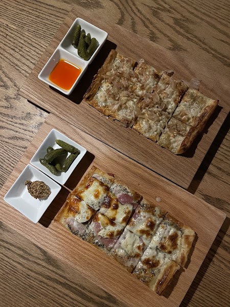 Toasted artisan flatbreads served on wooden boards with savory toppings and house condiments