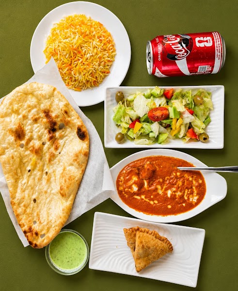 Traditional Pakistani mutton curry spread with naan and chutneys