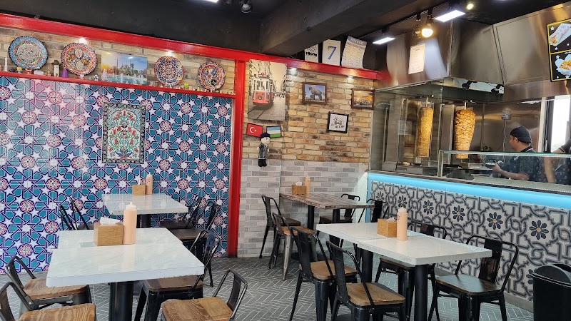 Interior of Troy Kebab showing tiled walls, dining seating, and vertical rotisserie