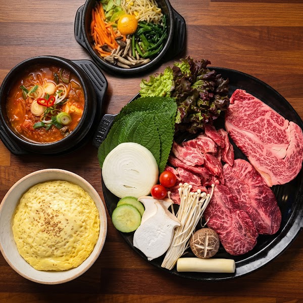 Banquet tabletop setup with side dishes, stew, and fresh vegetables