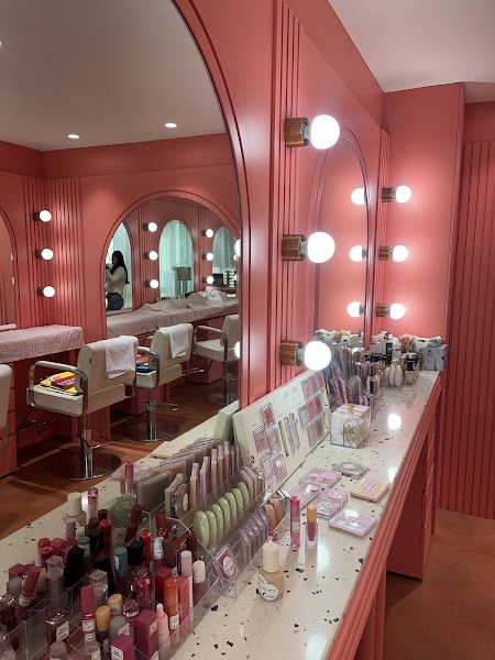 Interior of Colorize consultation studio in Myeongdong featuring coral walls, arched mirrors, and vanity makeup stations